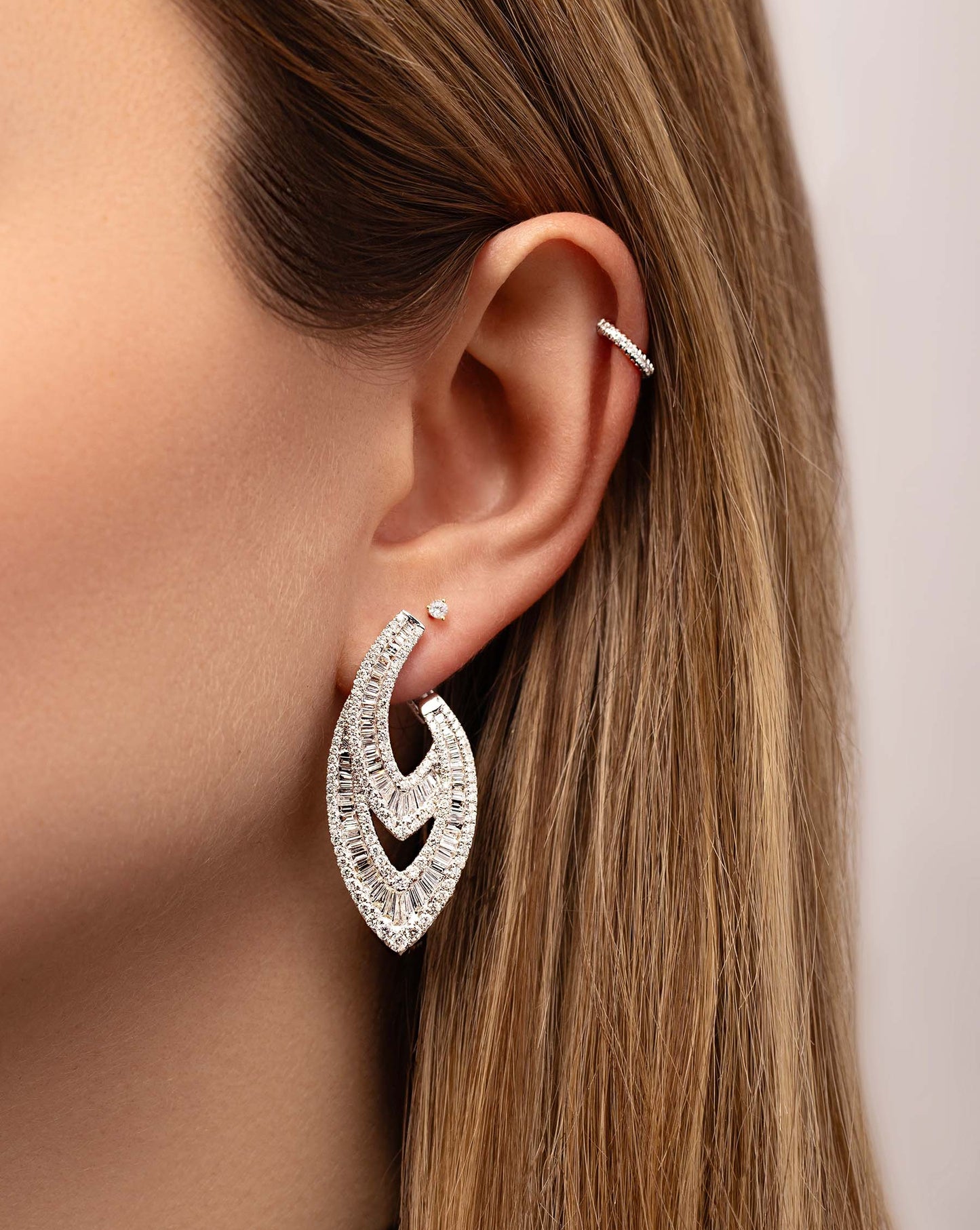 Art Deco Earrings on model styled with tiny diamond stud and mini diamond ear cuff