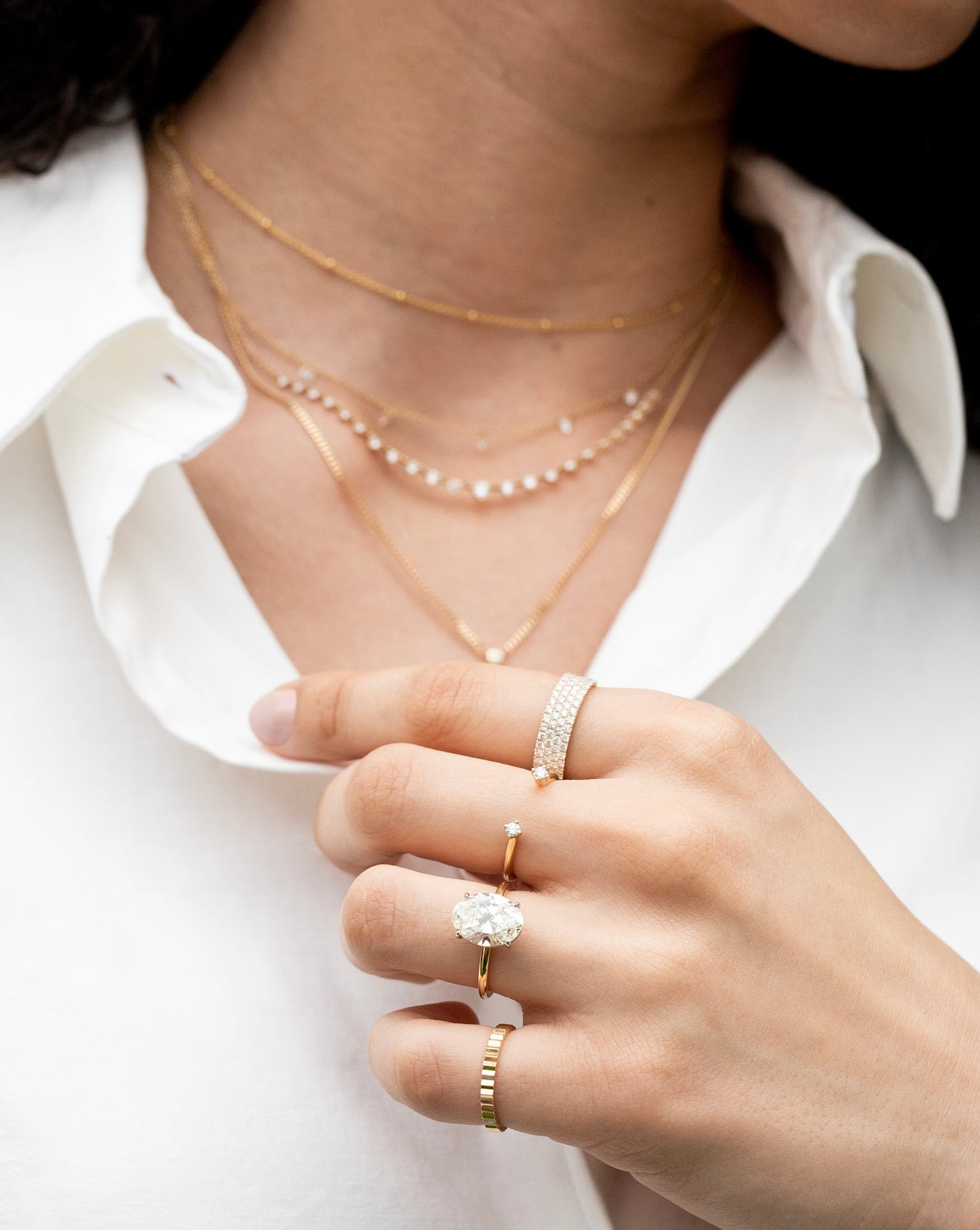 Ring Concierge Four Row Stackable Pavé Ring 14k Yellow Gold in model worn on pointer finger, middle finger is Diamond Duo Open Ring, ring finger is oval engagement ring in 14k yellow gold whisper thing setting and pinky finger is fluted ring