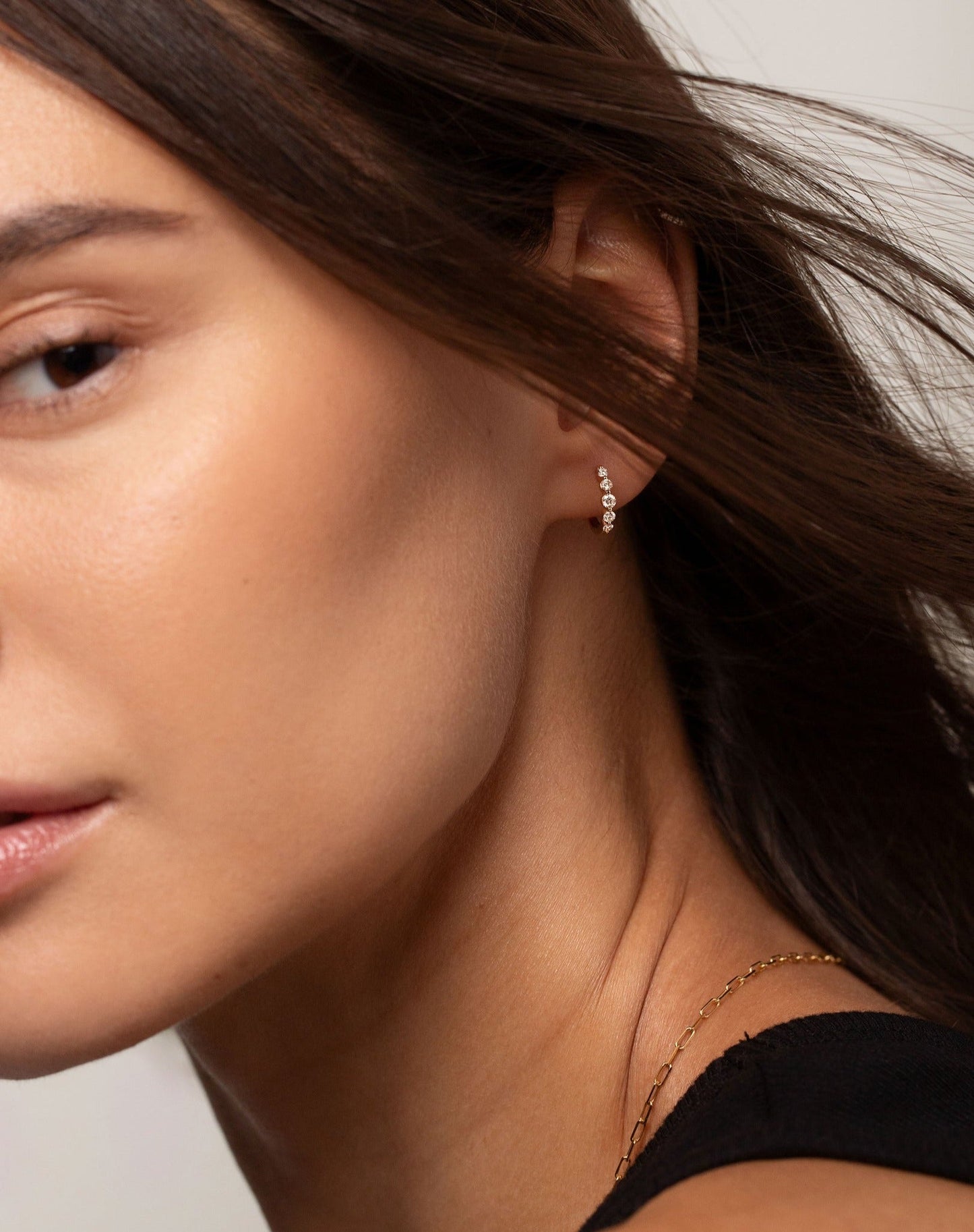 Graduated single prong diamond huggies shown on model