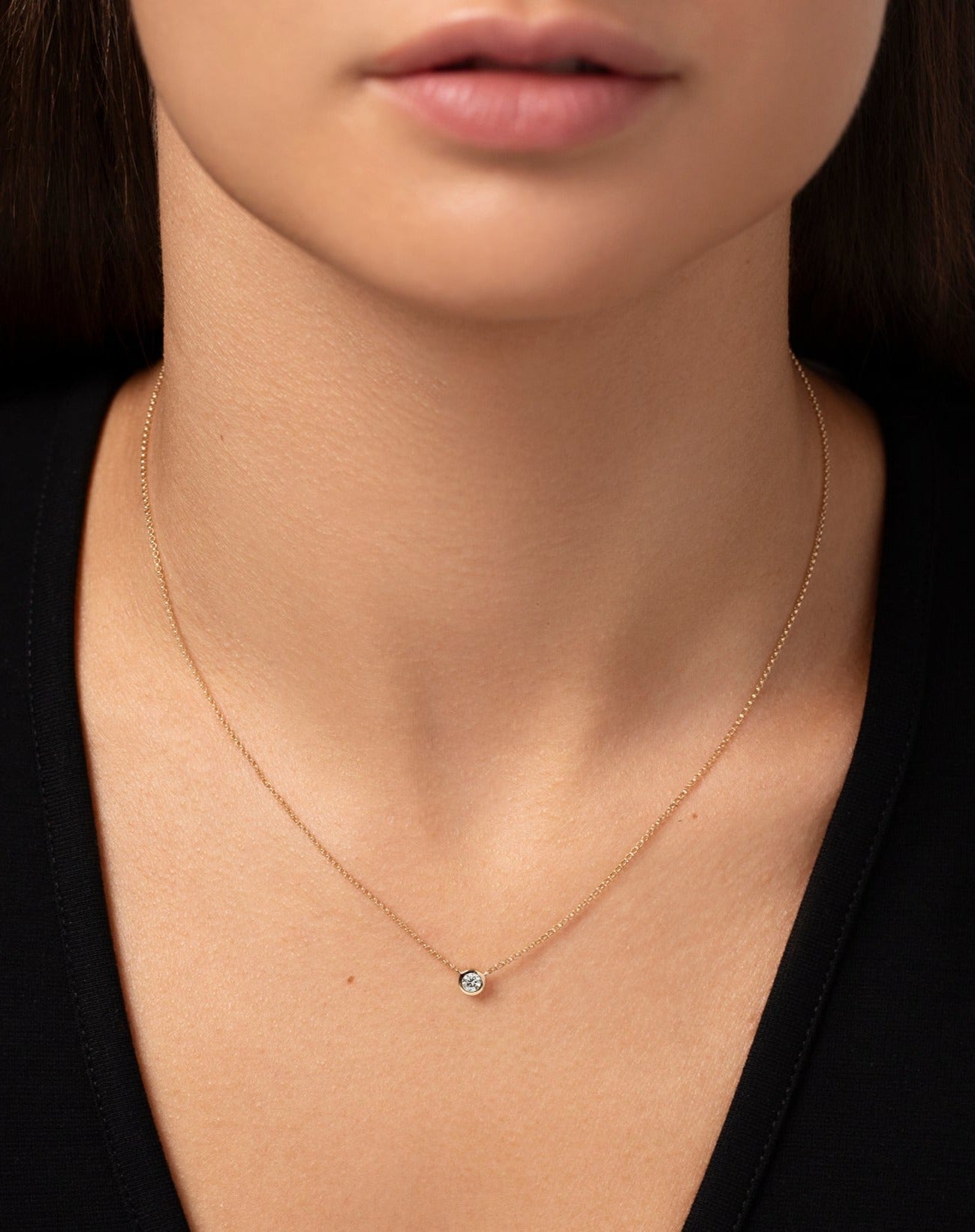 14k yellow bezel-set round diamond pendant necklace shown on model