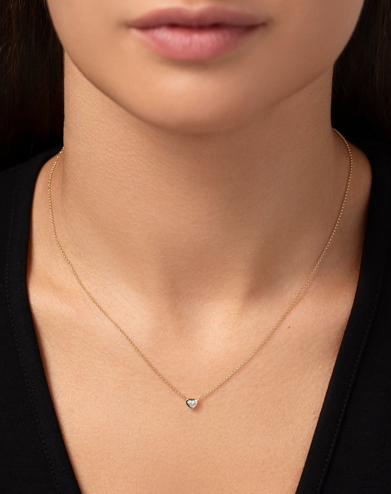 14k yellow gold bezel-set heart diamond pendant necklace shown on model
