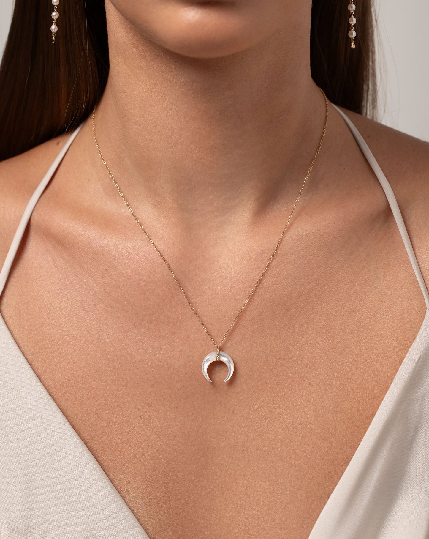 Mother of Pearl + Pavé Horn Necklace in 14kt yellow gold shown on model's neck