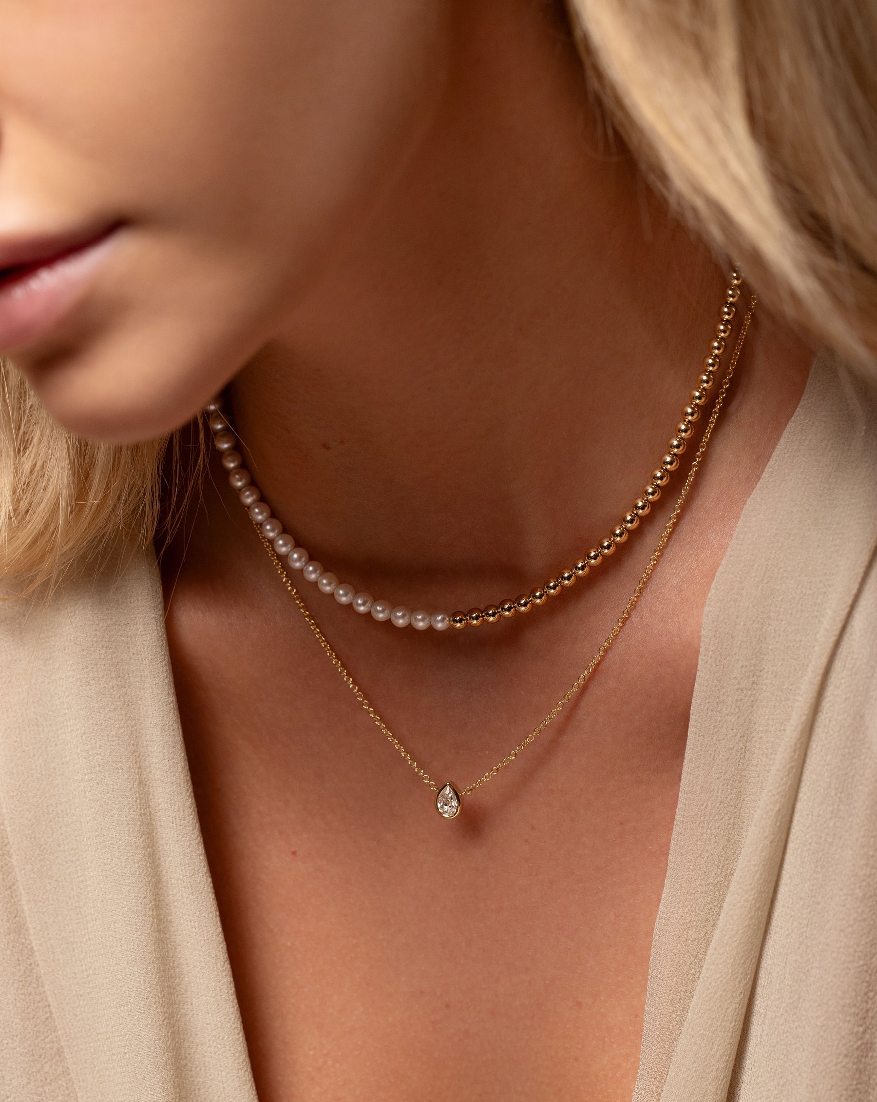 Multiway Pearl and Gold Beaded Necklace + Double Wrap Bracelet worn on neck with the pear shaped Half Carat Mixed Shape Necklace 