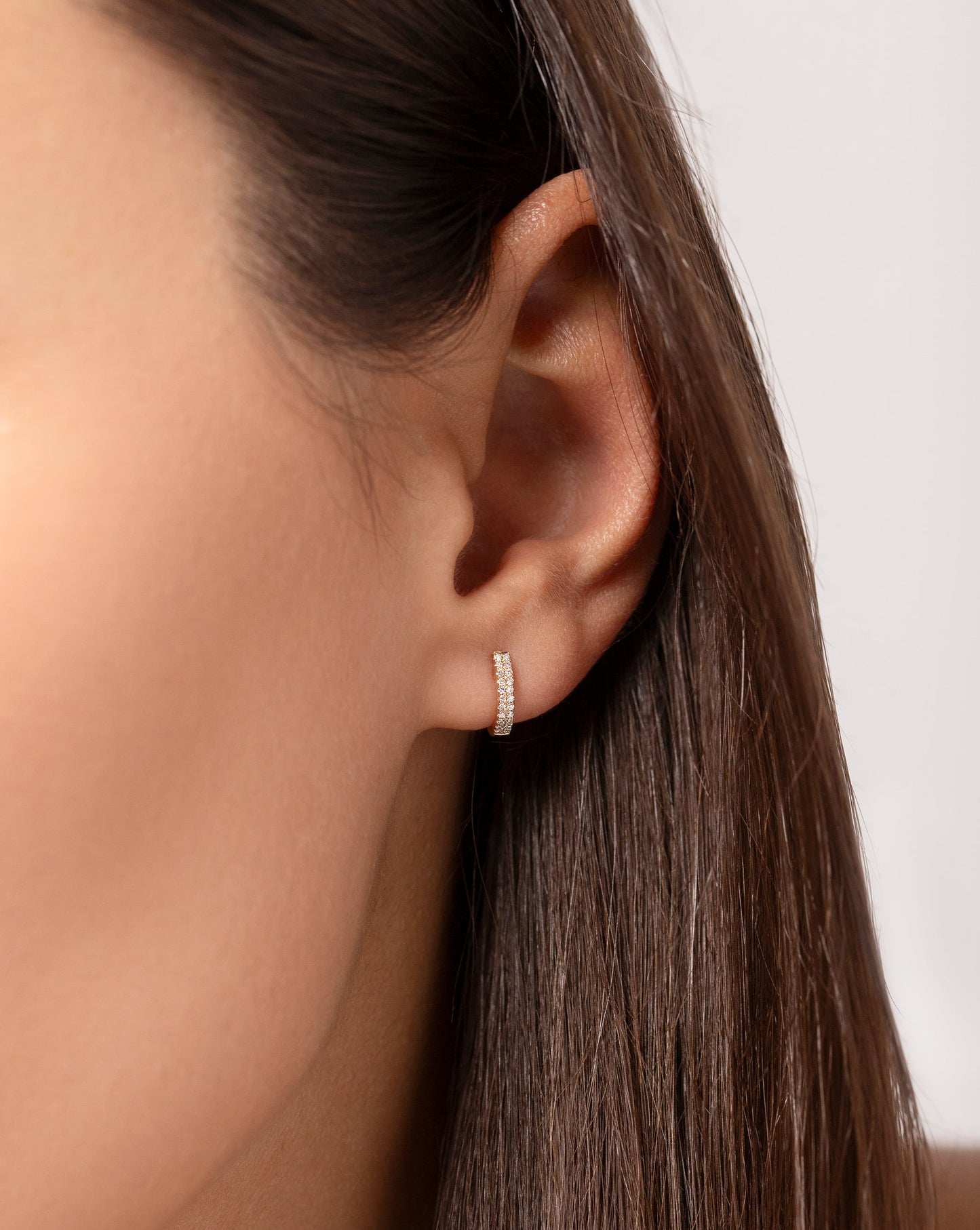 Close up image of the Petite Double Row Huggies shown in ear of model