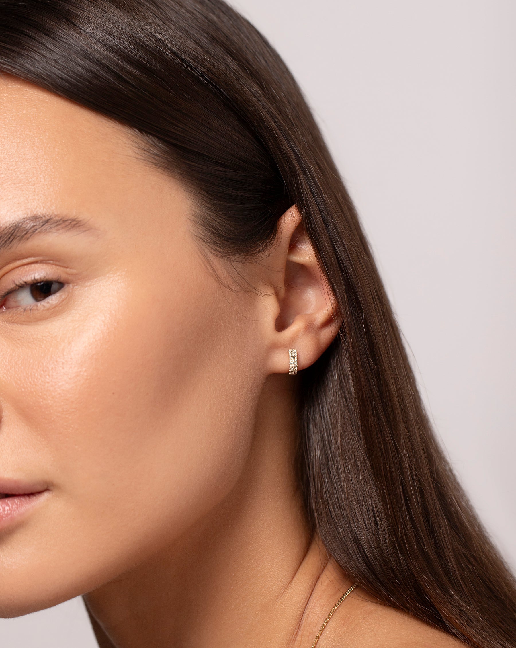 Petite Triple Row Huggies shown on model's ear