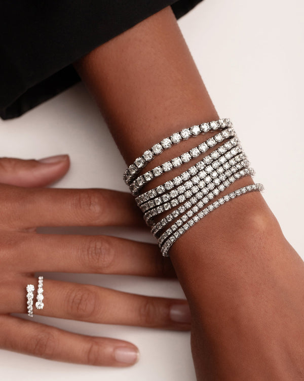 diamond wrap ring and eight diamond tennis bracelets stacked on model