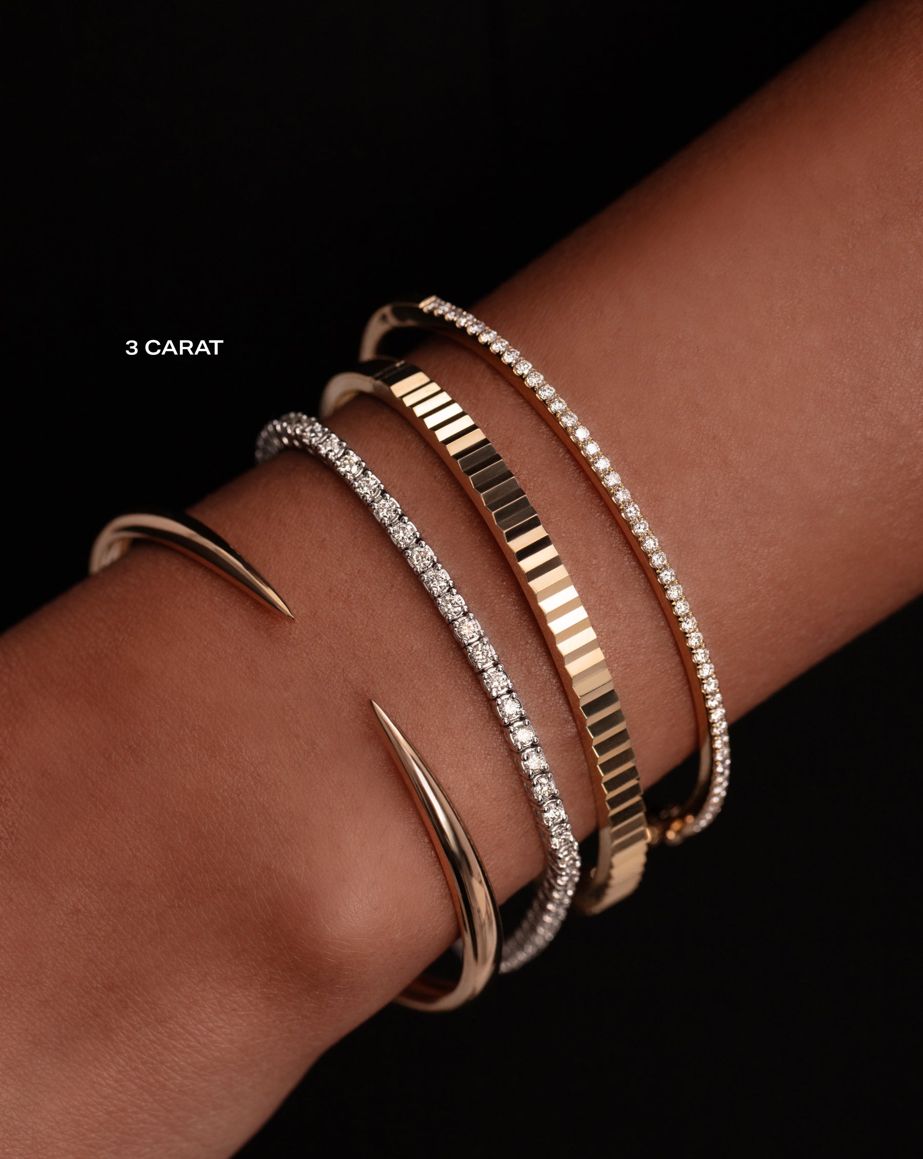 classic diamond gold bangle, gold fluted bangle, three carat classic diamond tennis bracelet, and gold claw cuff on model