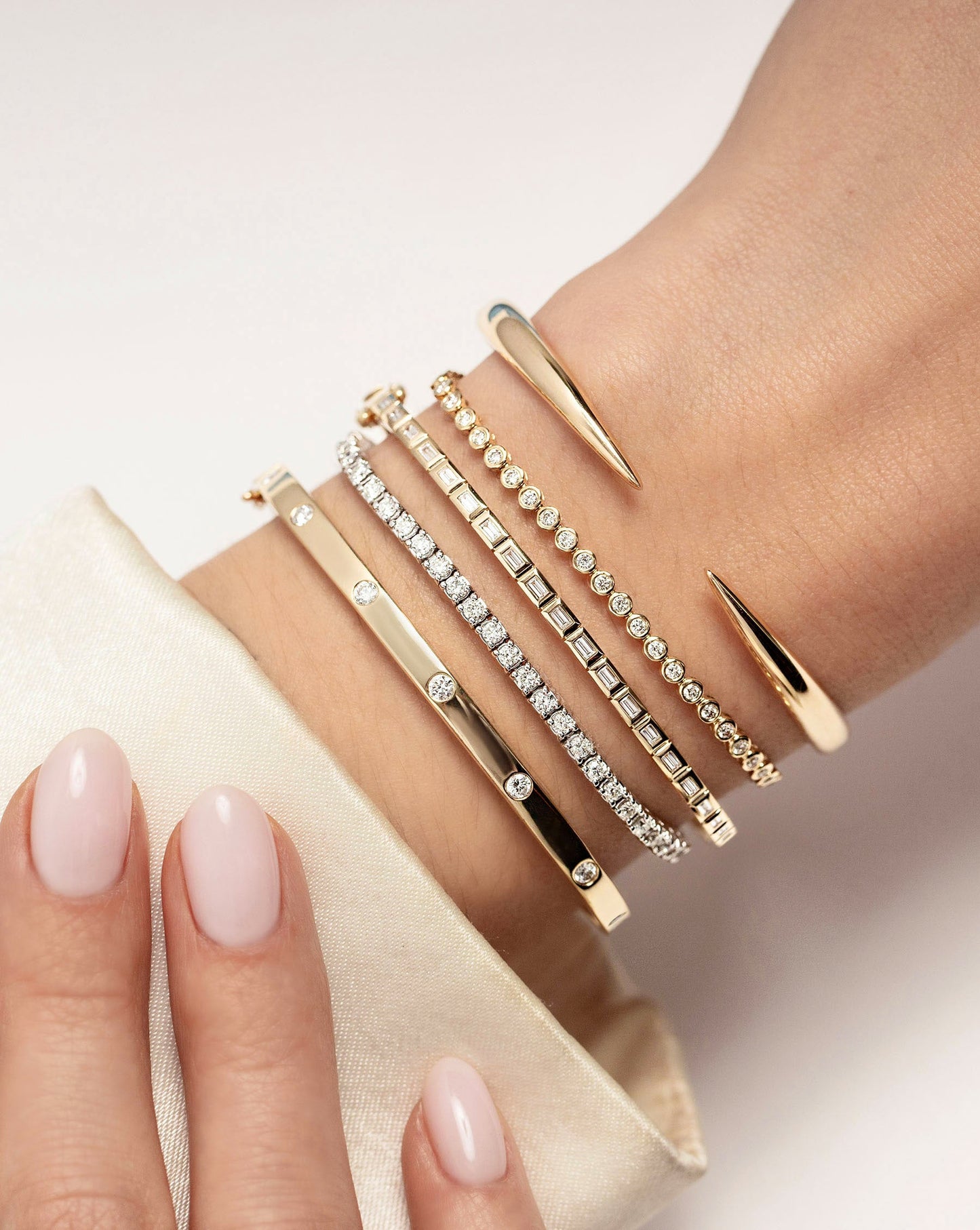 Baguette Bezel Bangle in yellow gold styled with other bracelets