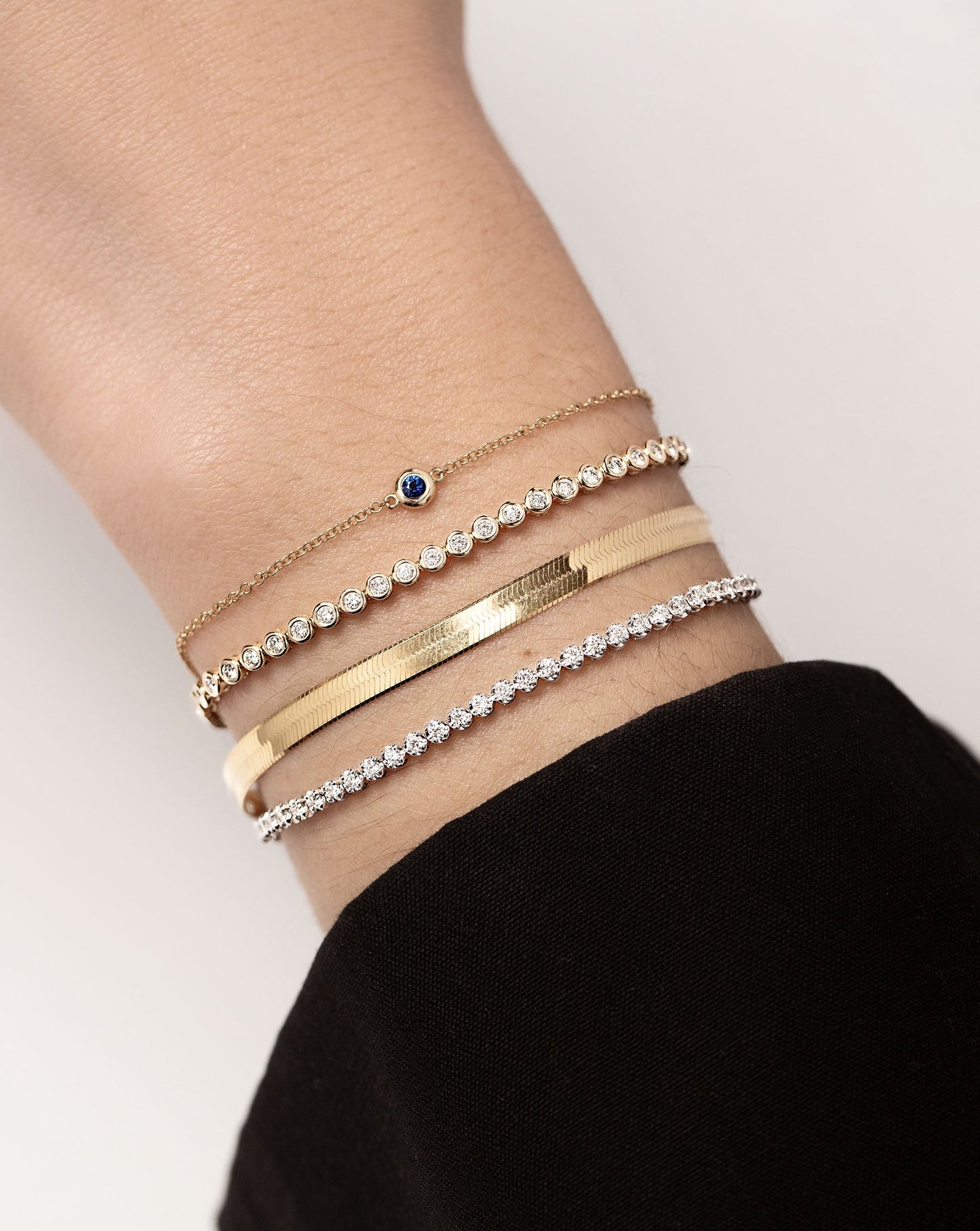 Gemstone Bezel-Set Bracelet styled with Bezel Mini Diamond Tennis Bracelet, Herringbone Chain Bracelet and Mini Diamond Tennis Bracelet on model