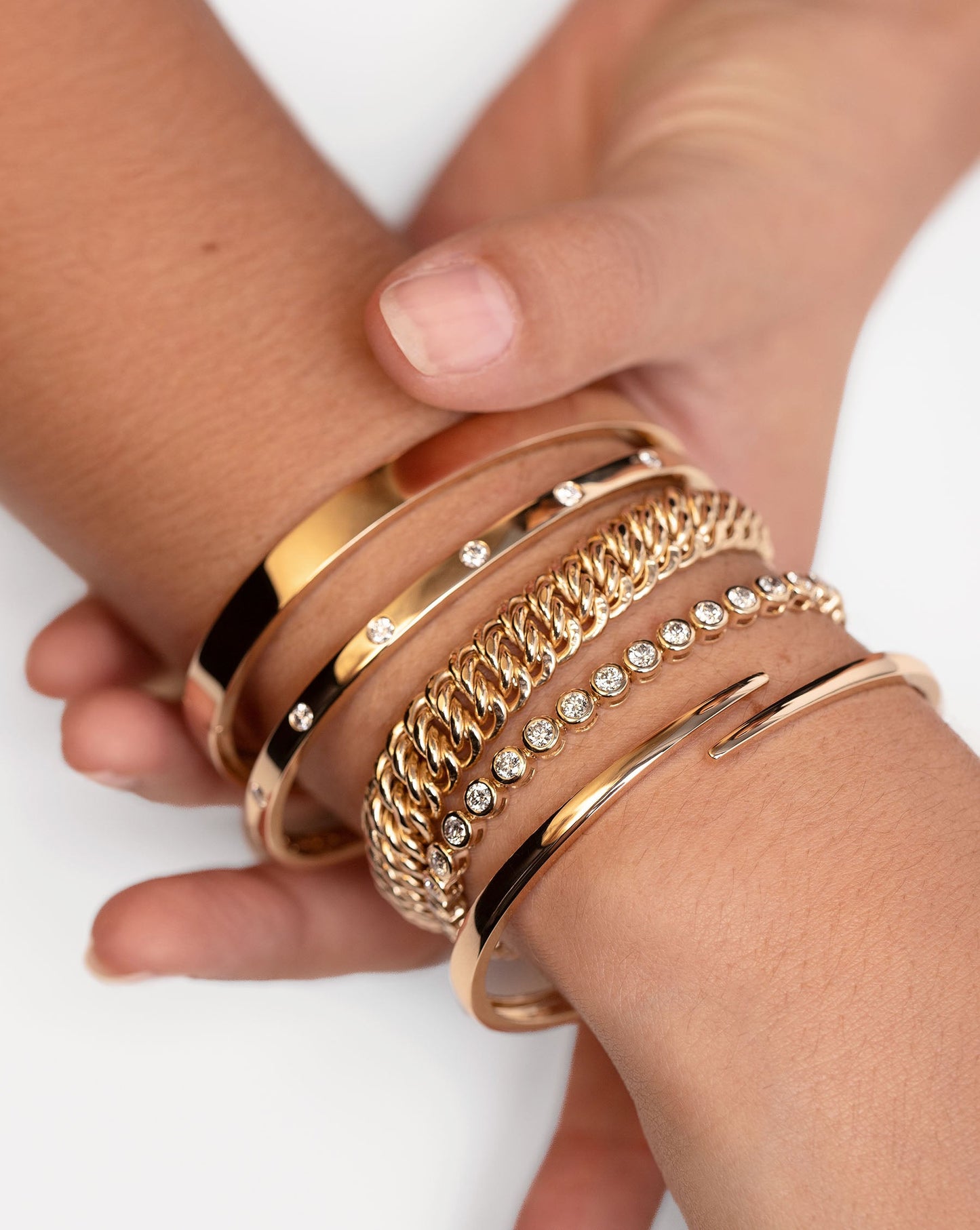 Open Wrap Gold Bangle on model stacked with 4 other gold and diamond bracelets