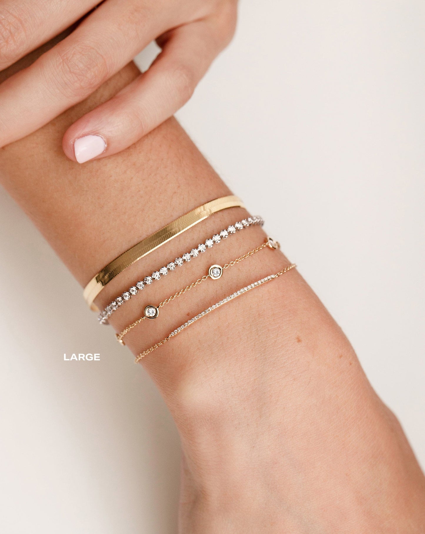 Herringbone Chain Bracelet worn on wrist with the Mini Diamond Tennis Bracelet, Diamond Bezel Set Station Bracelet and Diamond Bar Bracelet