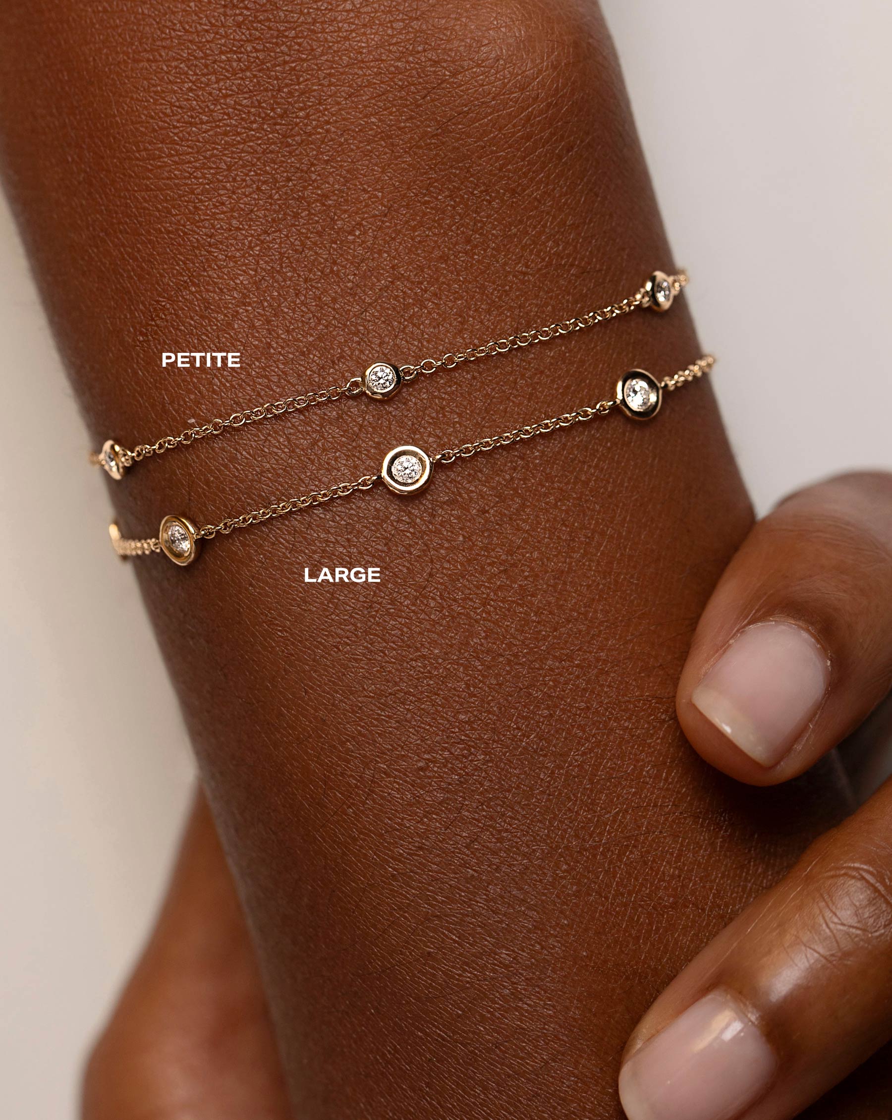 comparison shot of petite bezel-set round diamond station bracelet and large bezel-set round diamond station bracelet on model
