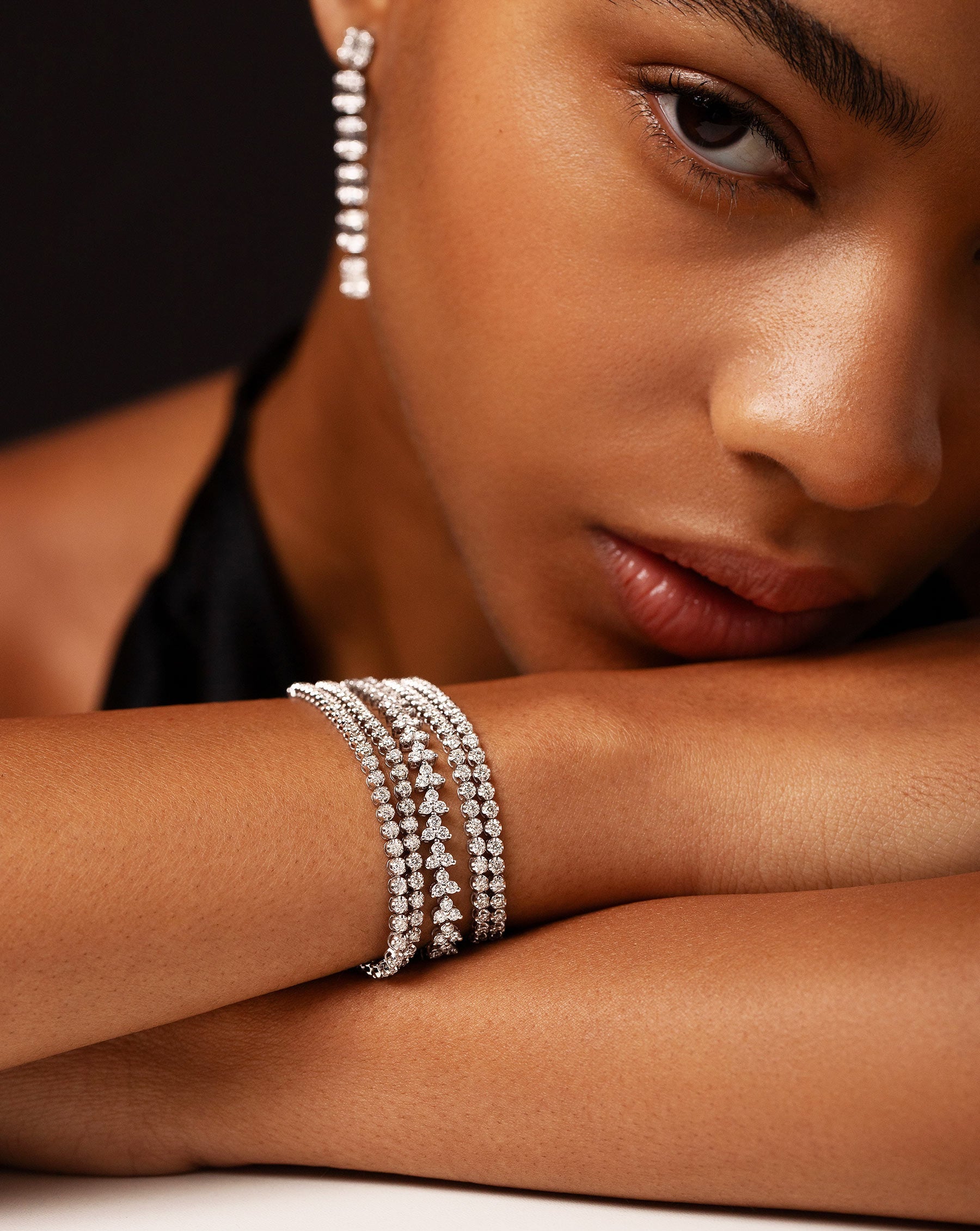 Model wearing 2 multiway tennis necklace + double wrap bracelets and a trip diamond tennis bracelet