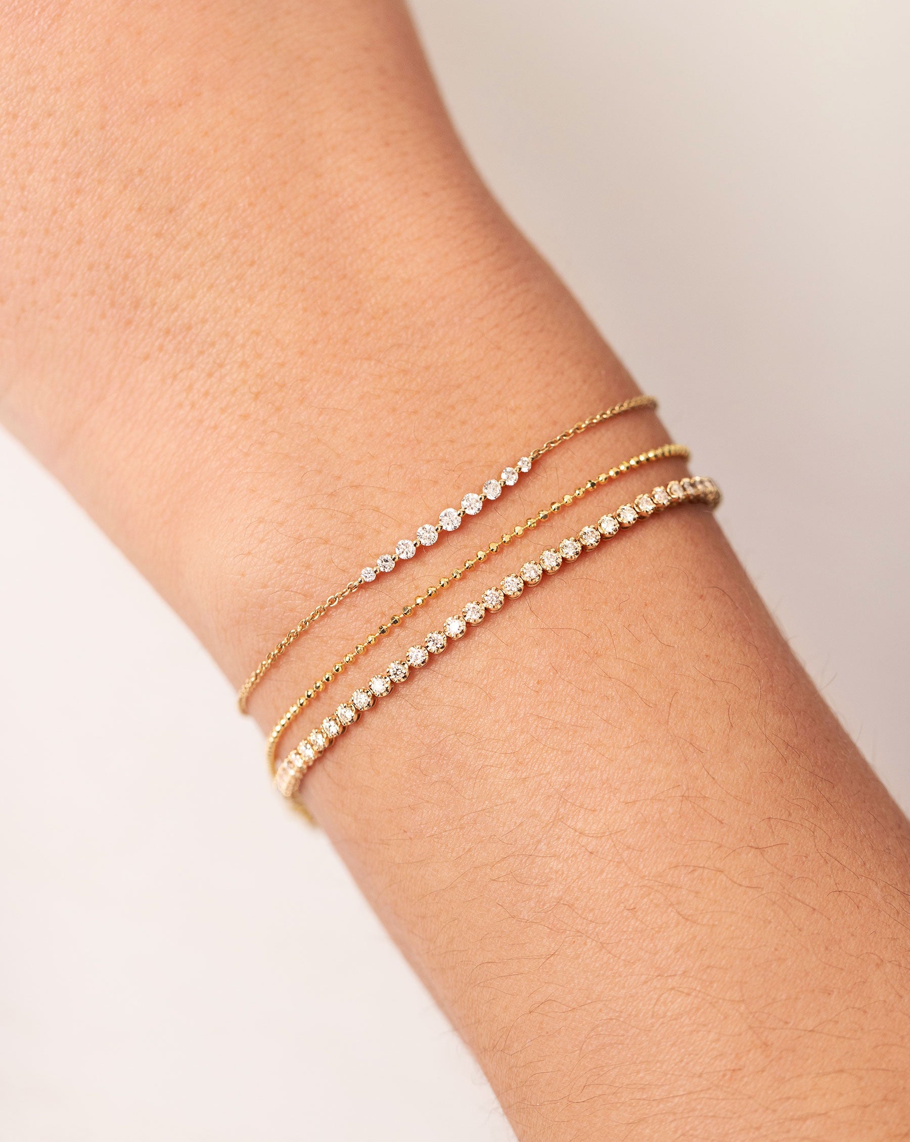 Graduated Single Prong Diamond Bracelet styled with 2 soft chain bracelets on model