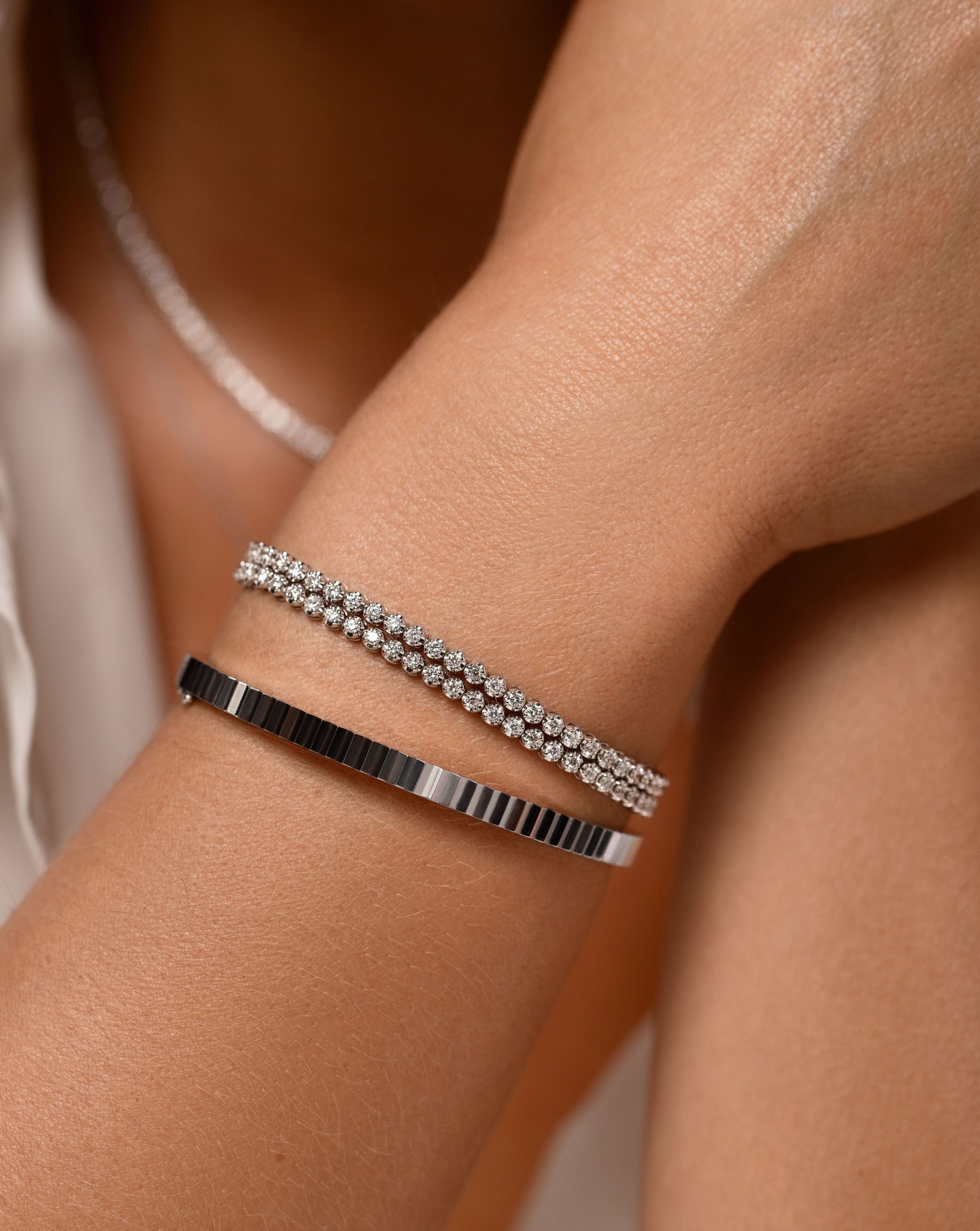 diamond double wrap bracelet and gold faceted bangle on model 14k white gold