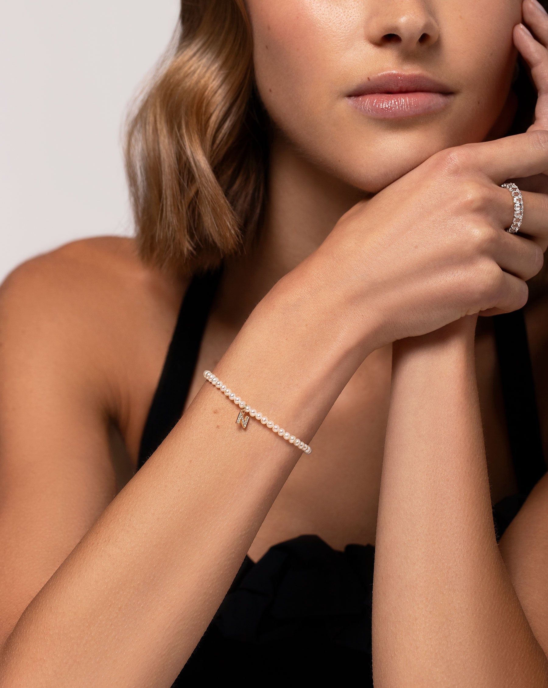 Petite Emerald Cut White Topaz Ring worn on middle finger of model shown with the Pearl + Pave Initial Bracelet