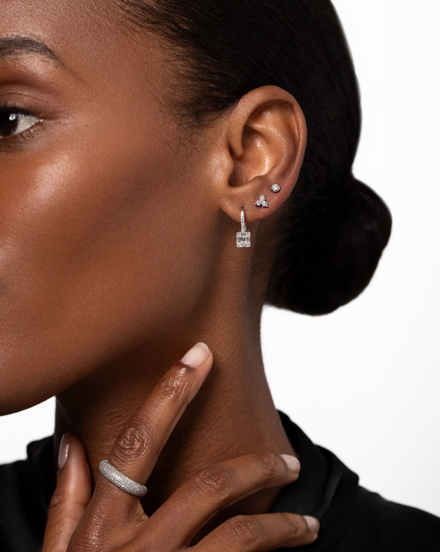 Bezel-Set Petite Diamond Studs on ear with the Emerald Illusion Lever Back Earrings and Diamond Trio Studs styled with the Pave Diamond Cloud Ring