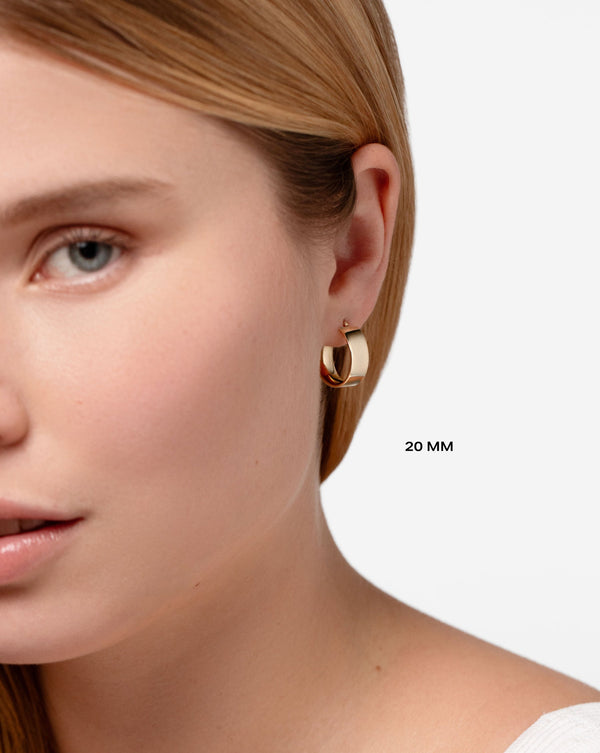 20 mm Bold Gold Flat Hoops worn in ear of model