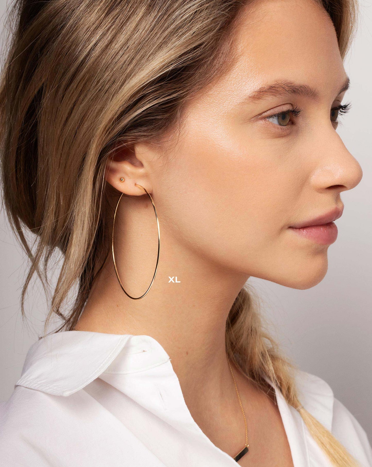 Size extra large 1 mm Endless Gold Tube Hoops worn with the Petite Gold Bead Studs in ear of model