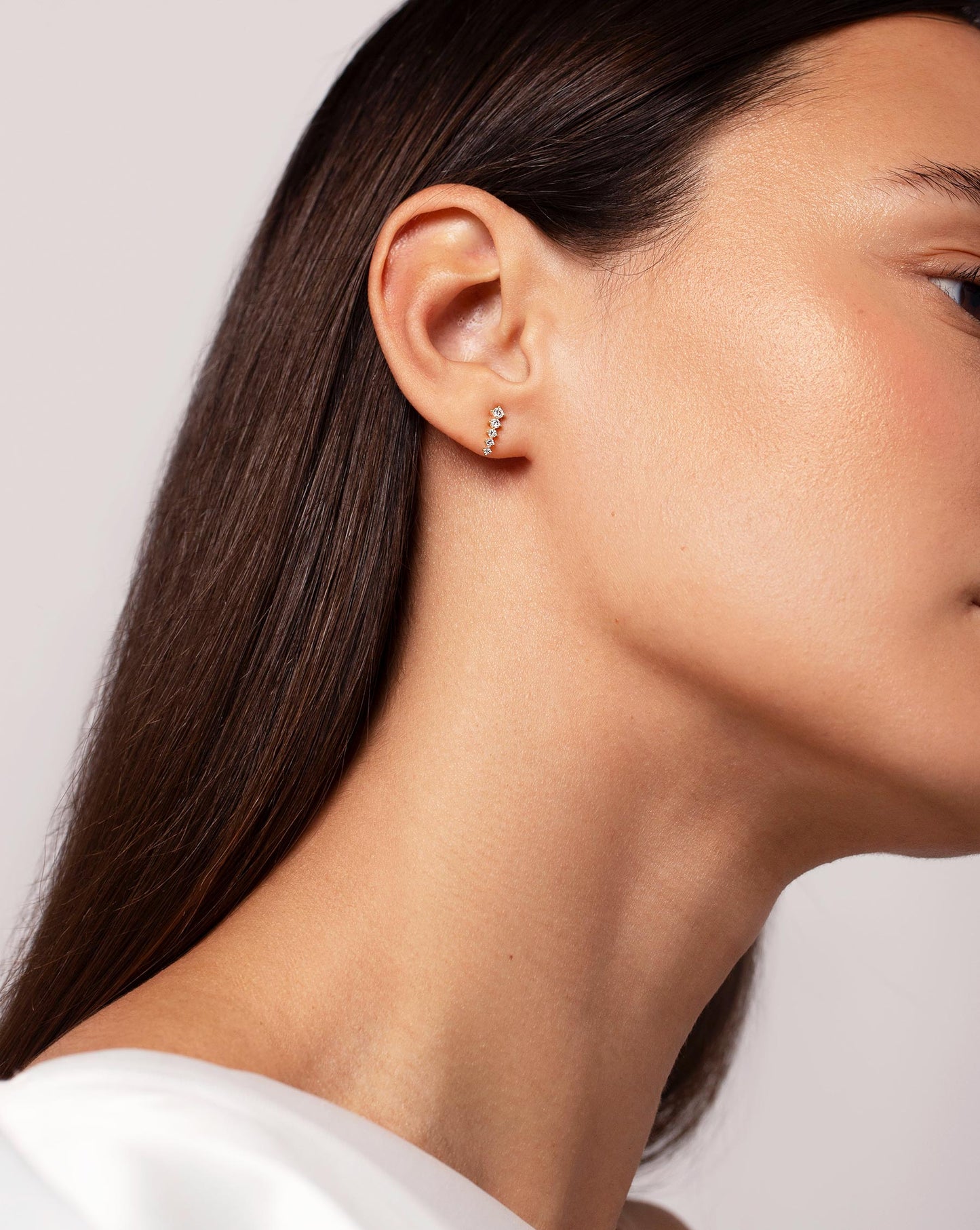 Graduated Curved Studs on ear of model with head slightly tilted away