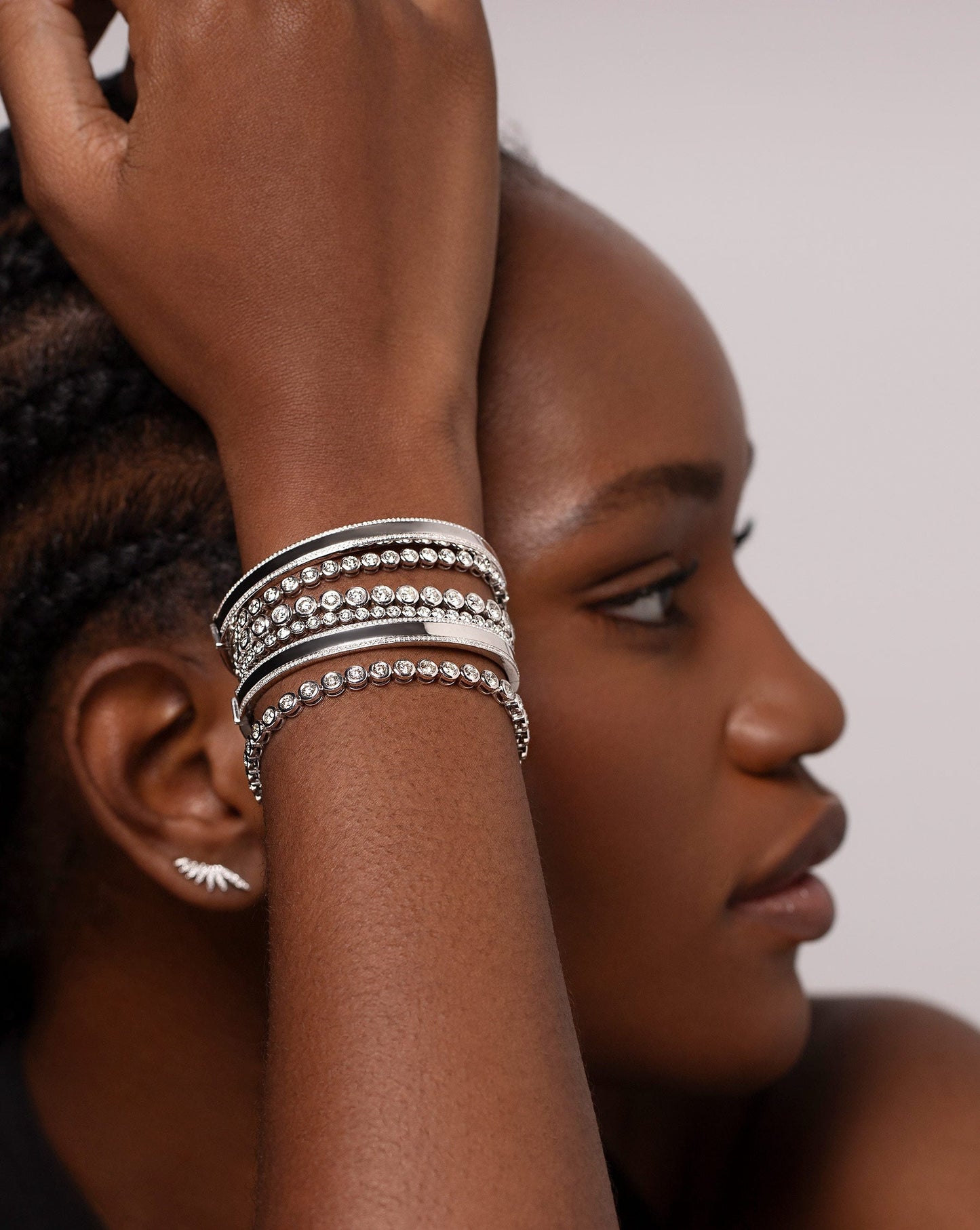 Model wearing two Diamond Border Bangles and four Bezel Set Classic Diamond Tennis Bracelets