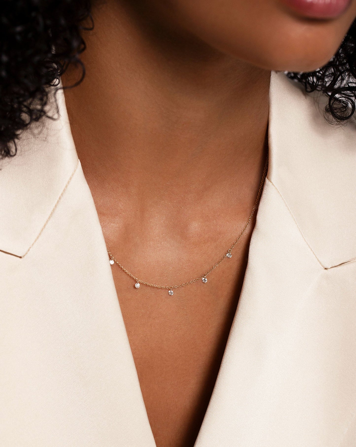 Floating Diamond Necklace shown on neck of model wearing white blazer