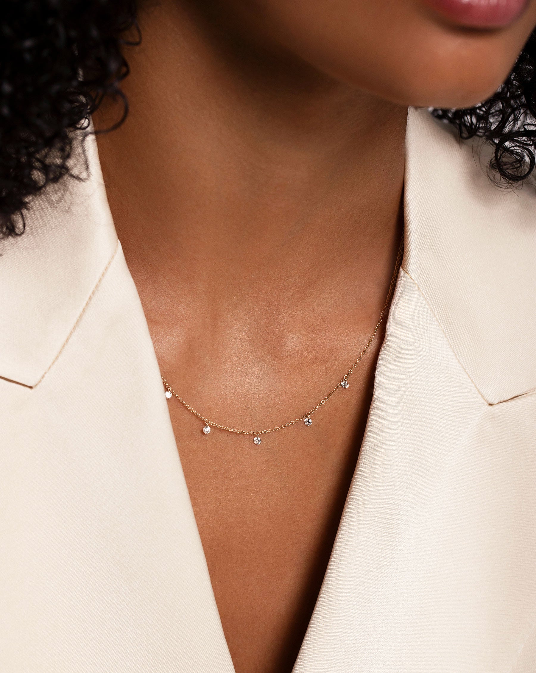 Floating Diamond Necklace shown on neck of model wearing white blazer