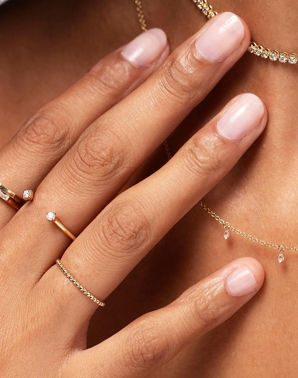 Model wearing Ring Concierge gold and diamond rings and necklaces
