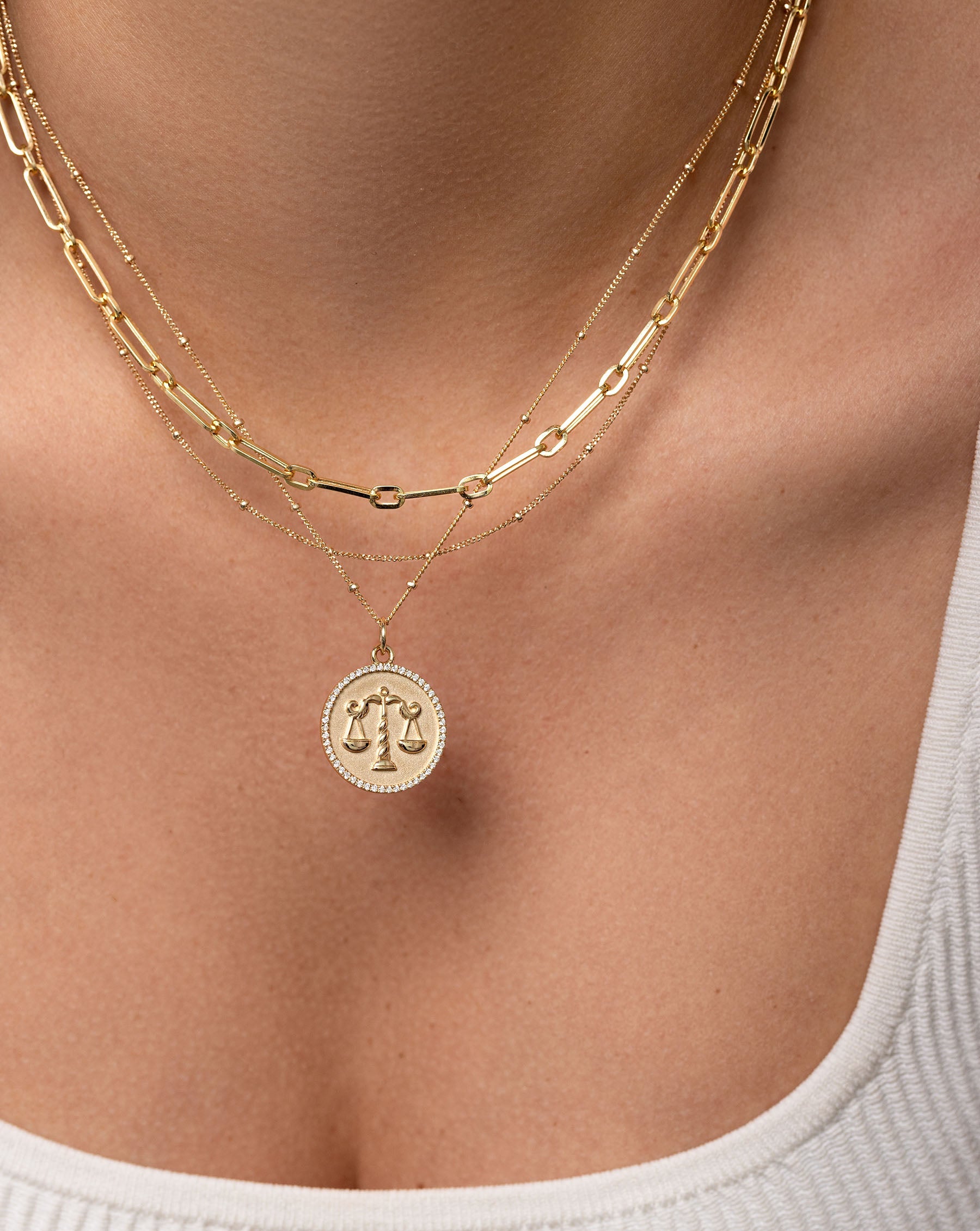 Zodiac Medallion Necklace on model styled with Long Link Chain Necklace and saturn chain necklace