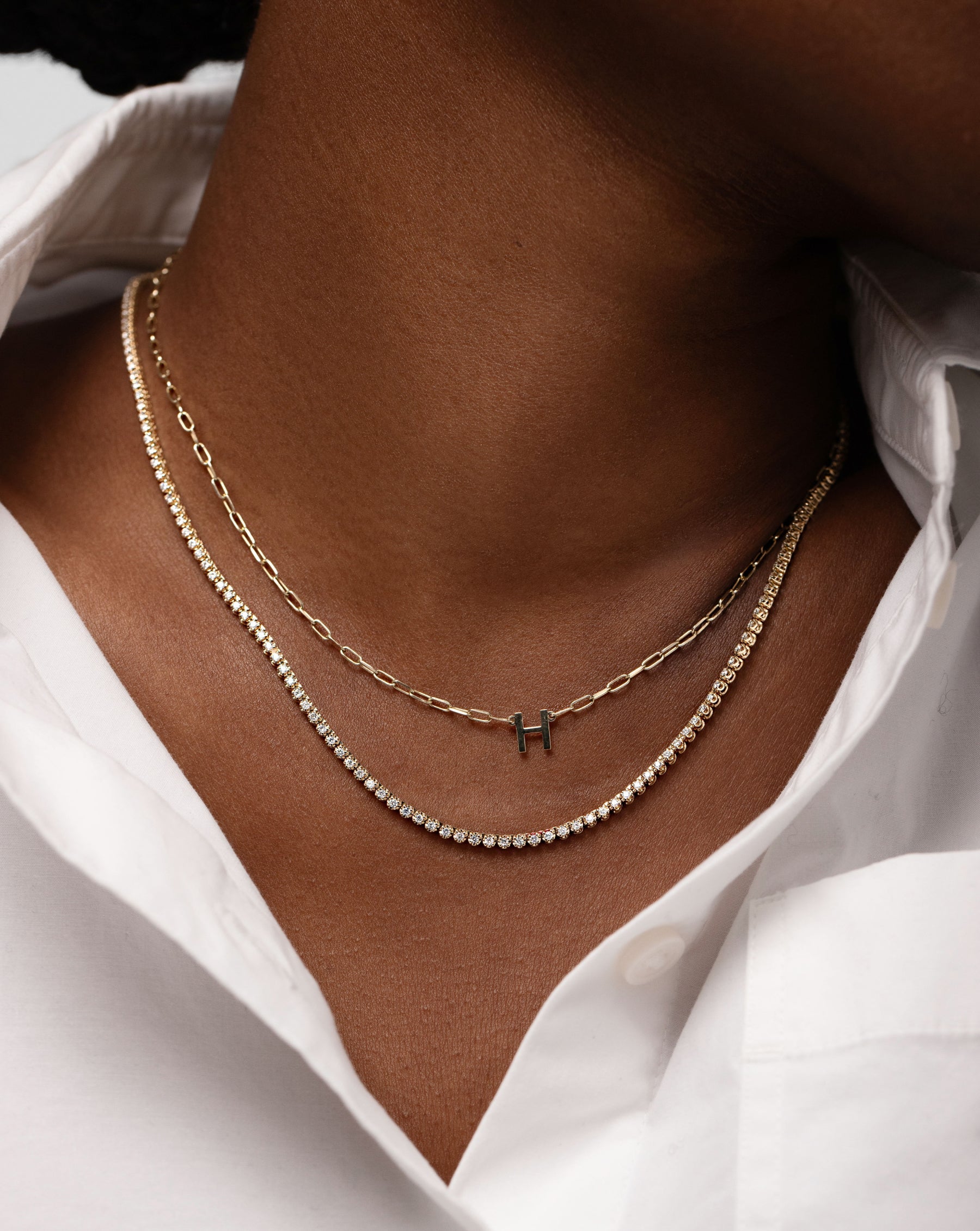 Block Initial + Link Chain Necklace with the letter H worn on model's neck with the Mini Diamond Tennis Necklace