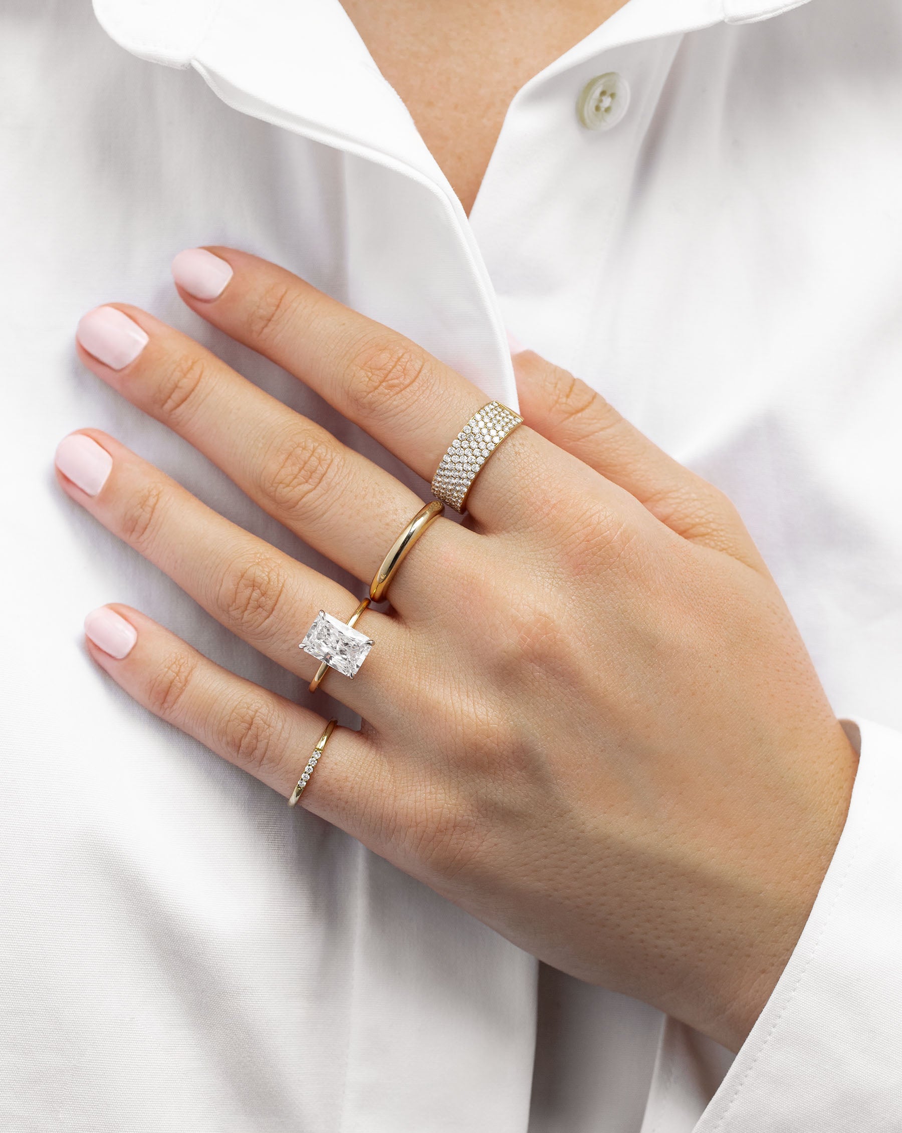 Diamond Row Stackable Ring on mode's pinky finger wearing white shirt