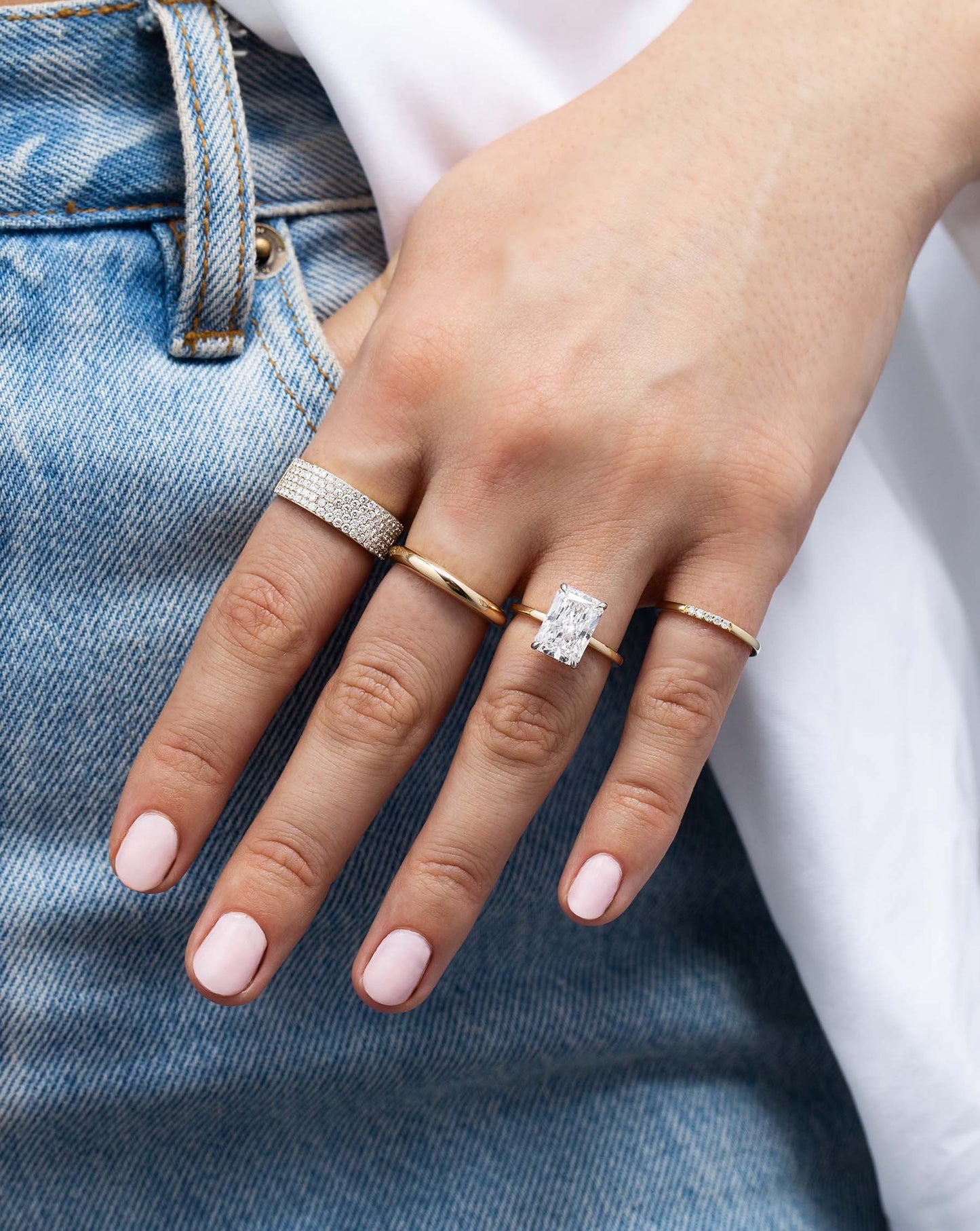 Five Row Stackable Pavé Ring styled with other rings on model wearing jeans