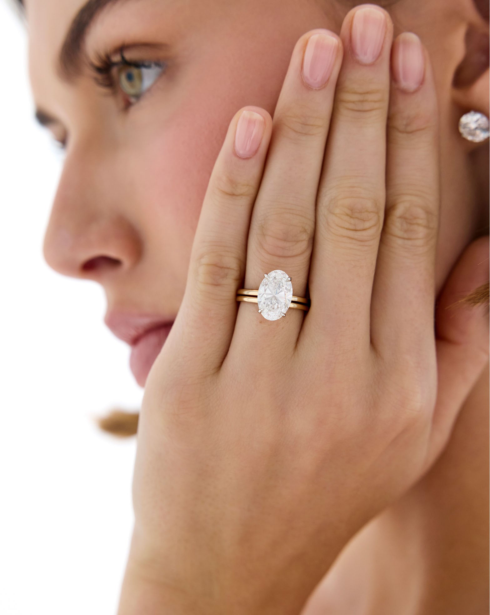 Model wearing Whisper Thin Band stacked with Oval Engagement Ring global