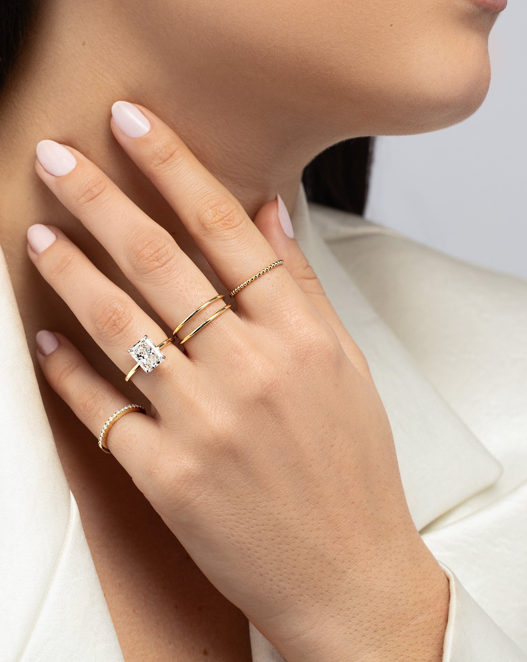 Beaded Stackable Ring on pointer finger styled with other rings on model's hand