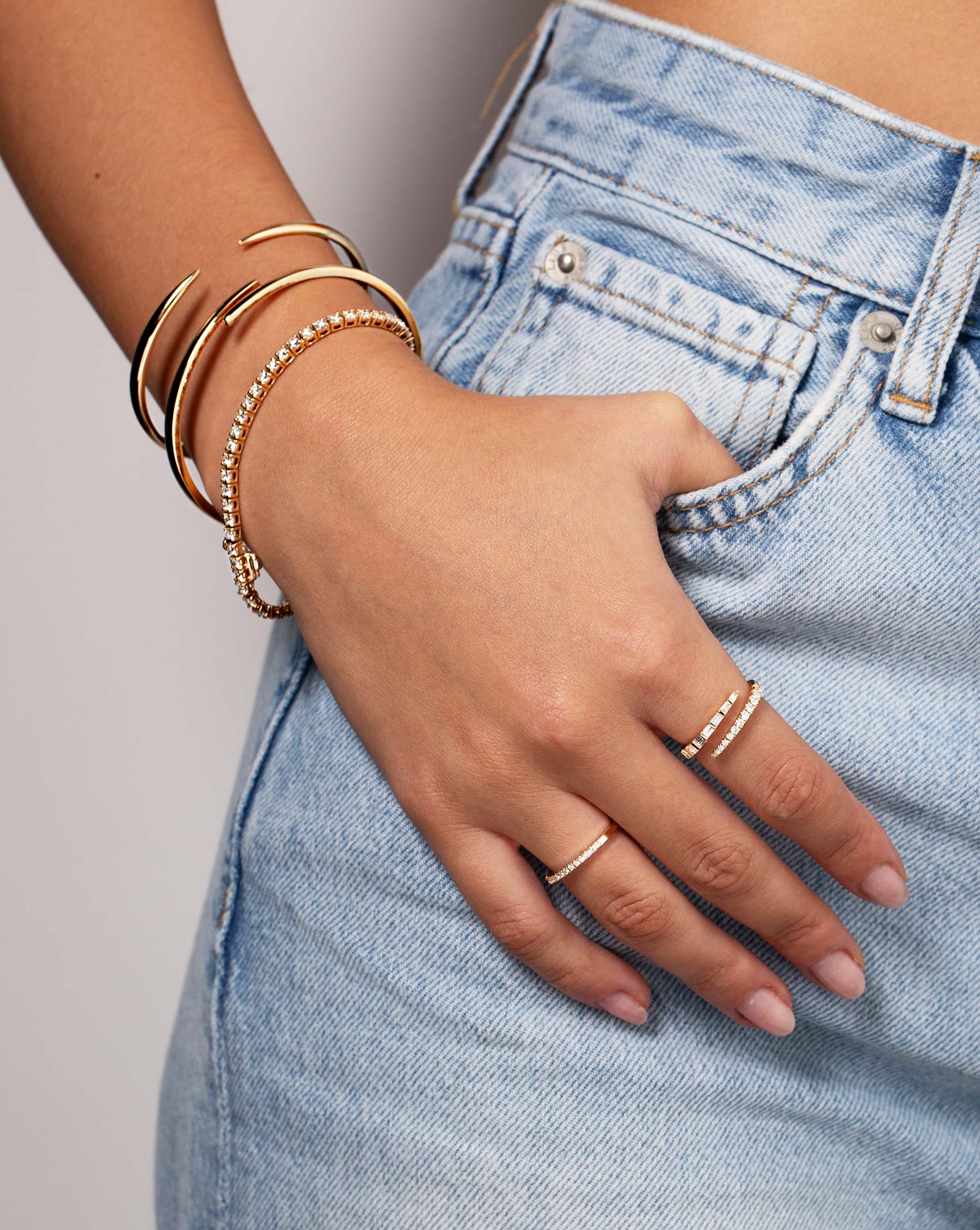 Luxe Open Diamond Wrap Ring worn on pointer finger along with the Stackable Pave Diamond Ring on ring finger. Model is also wearing the Gold Claw Cuff, Open Gold Wrap Bangled and the Classic Diamond Tennis Bracelet.