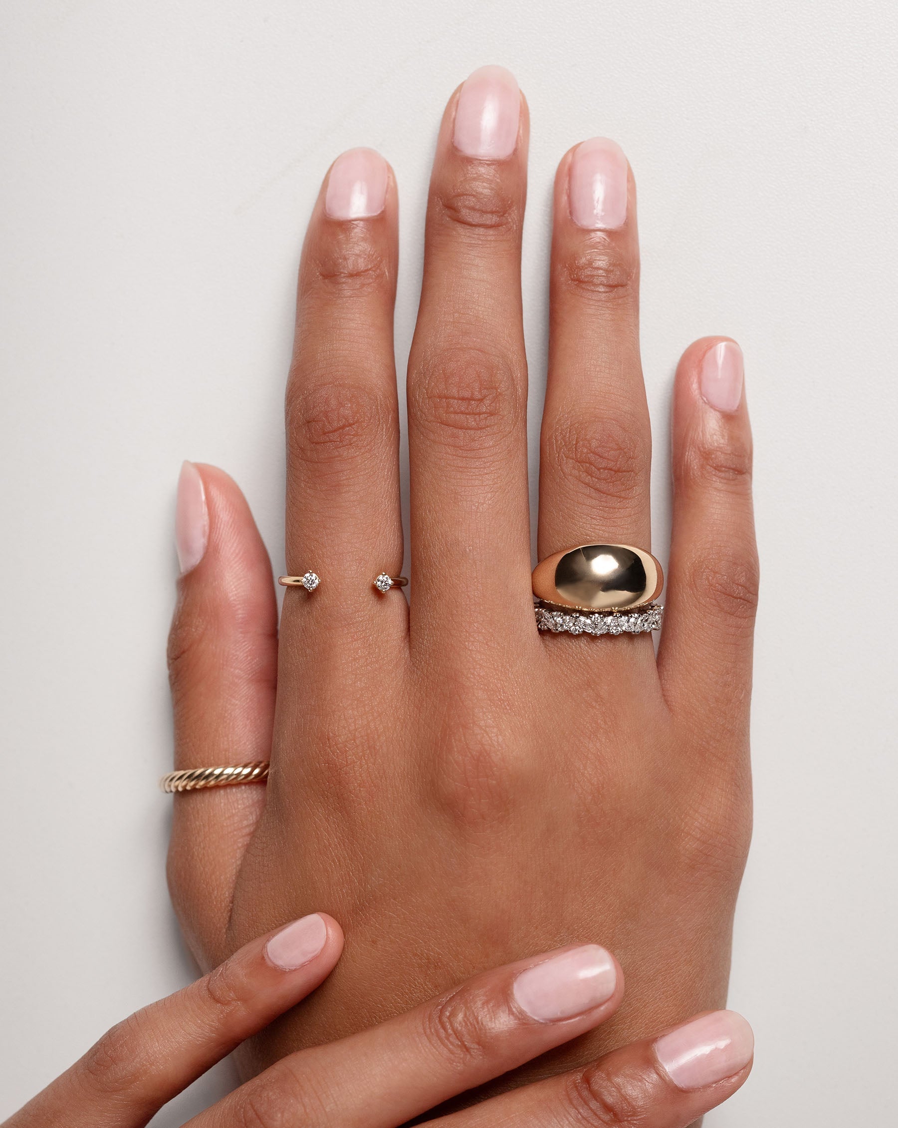 Ring Concierge twisted cable ring - on-model wearing the ring on her thumb and styled with gold rings