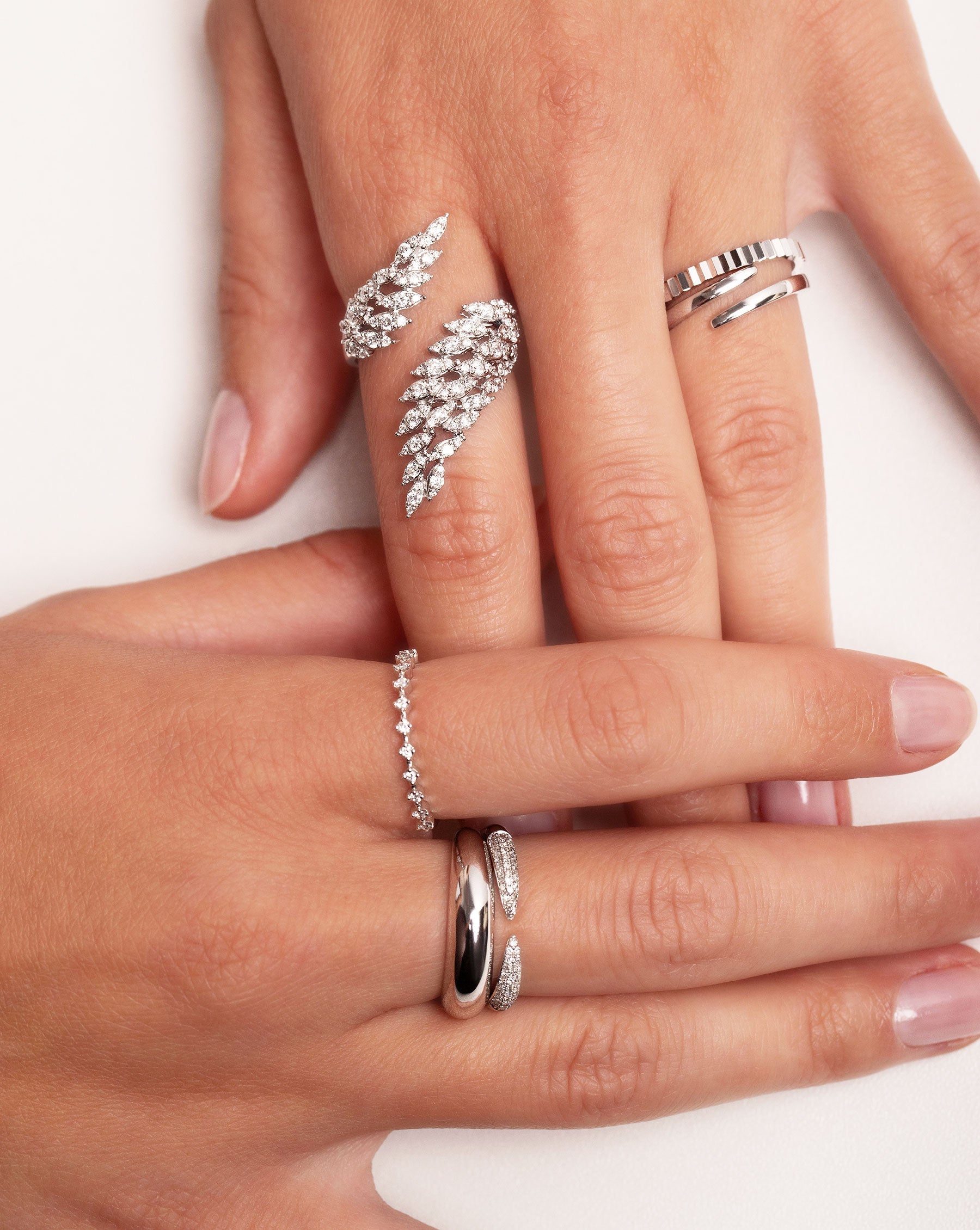 Marquise Illusion Diamond Wrap Ring on pointer finger of hand styled with the Open Gold Wrap Ring, Fluted Gold Stackable Ring, Diamond Station Ring, Triple Row Diamond Claw Ring and Gold Cloud Ring.