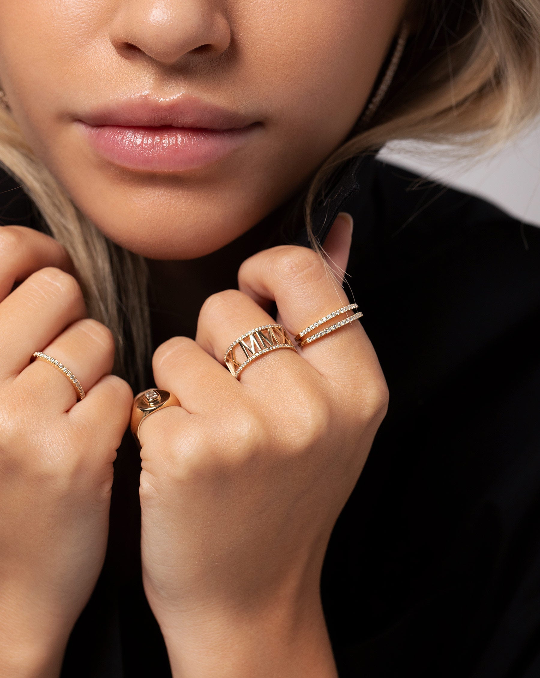 Diamond Roman Numeral Personalized Ring worn with three Stackable Pave Diamond Rings and the Diamond Signet Pink Ring on hands of model