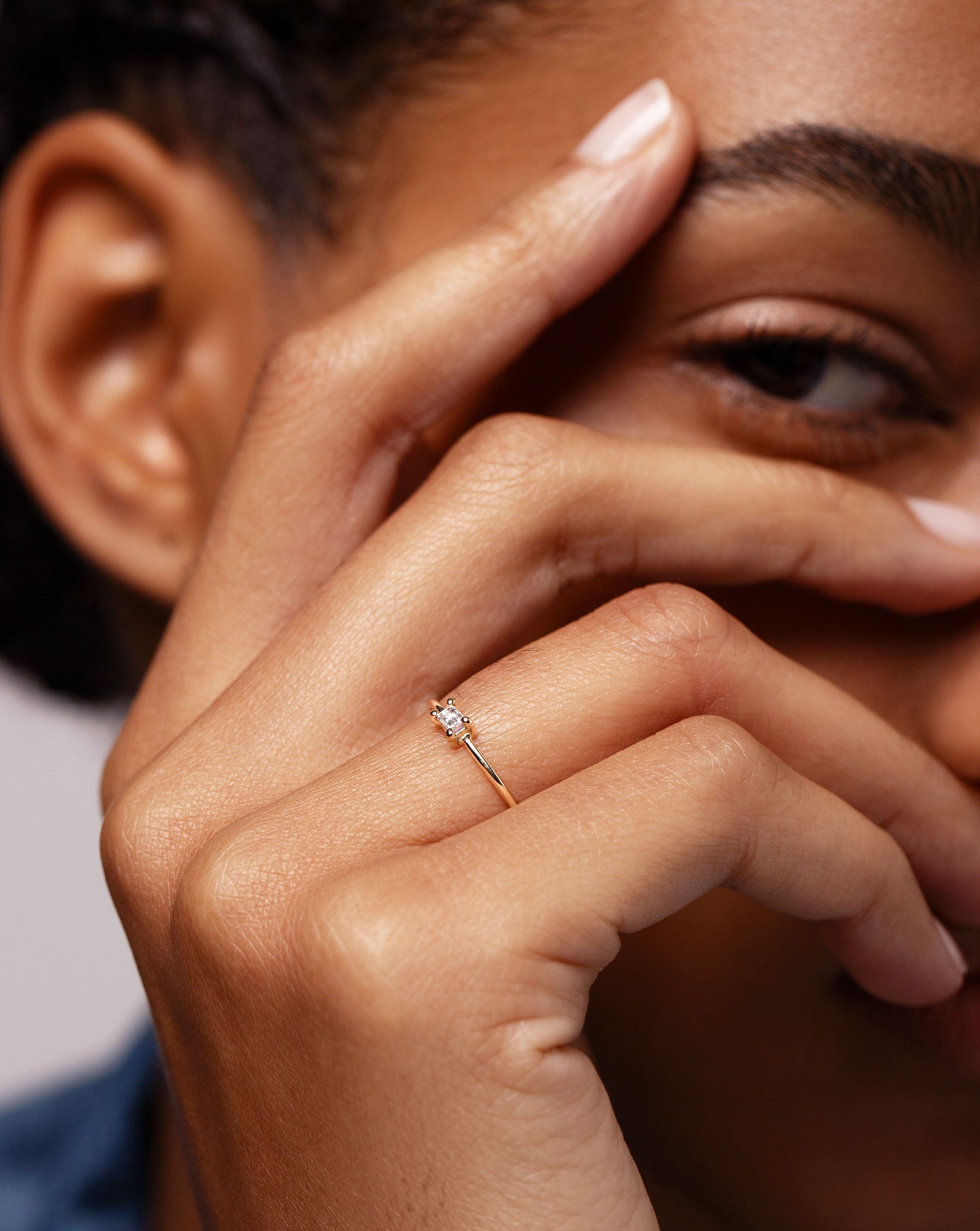 Close up image of the Single Emerald Diamond Ring worn on ring finger of model