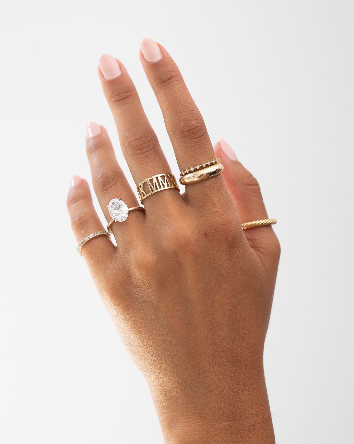 Ring Concierge on-model on hand with 5 gold and diamond rings and 1 engagement ring