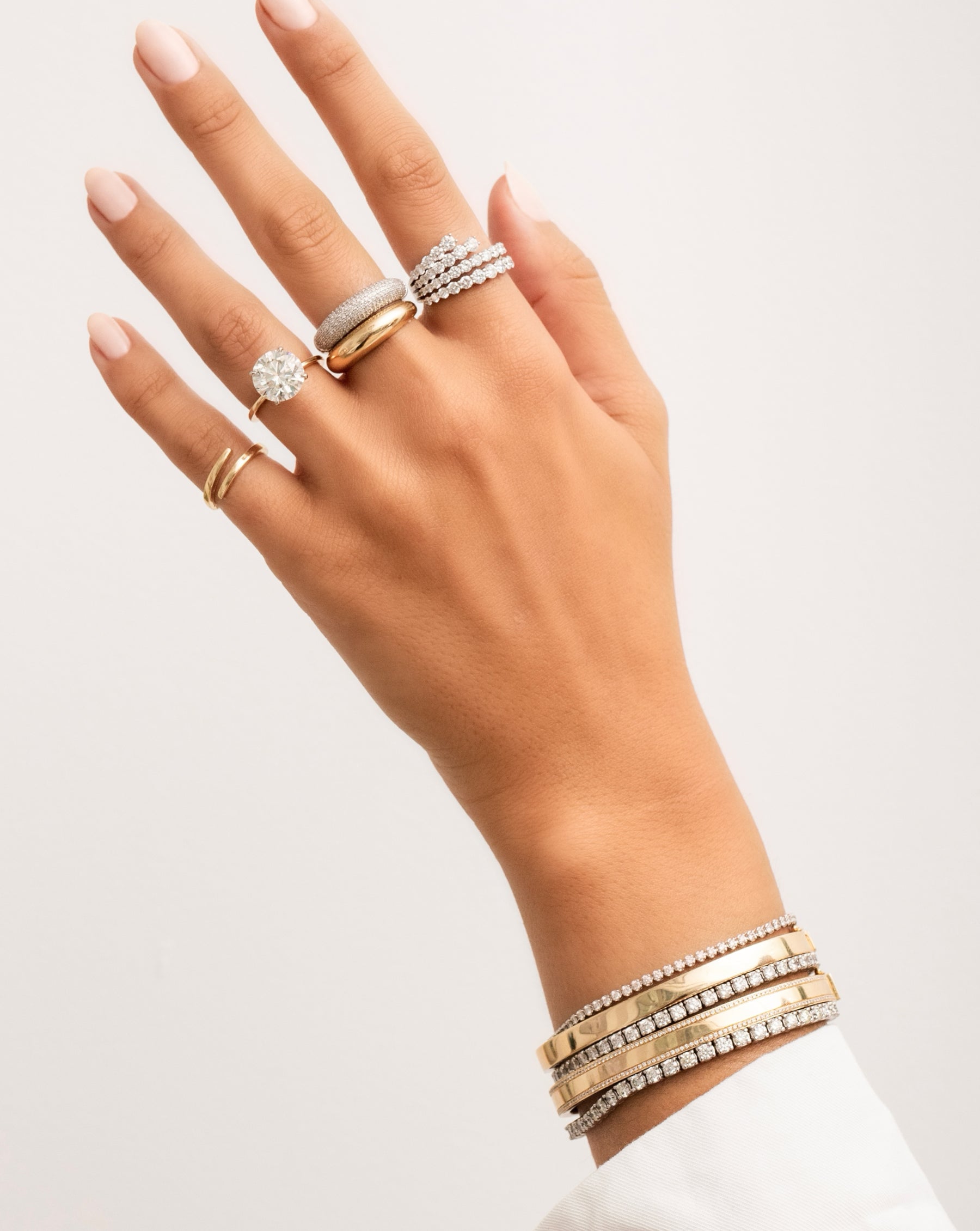 14k open gold wrap ring, round cut diamond engagement ring, pave diamond cloud ring, gold cloud ring, four row fanned diamond ring, three diamond tennis bracelets, and two gold bangles on model