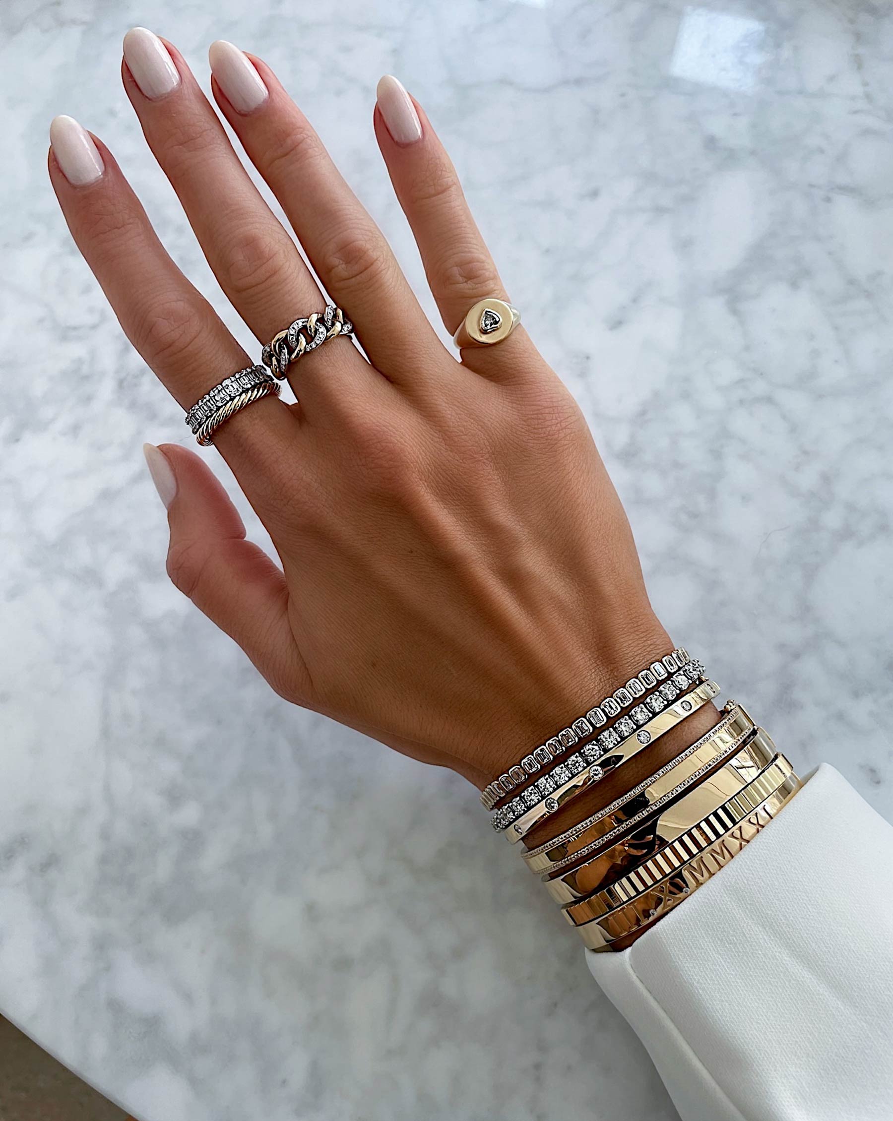 Ring Concierge twisted cable ring - on-model wearing the ring on her pointer finger and styled with gold rings and bracelet stack of mixed metals